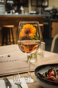 uma taça de vinho ao lado de um prato principal em um restaurante sofisticado